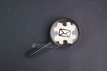 magnifying glass and wooden puzzle with email icon