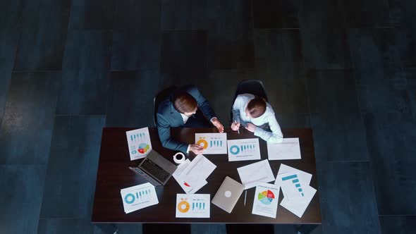 Two young business people discussing a project in a loft