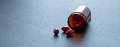 Red capsule pills and brown plastic bottle on dark background. Pharmacy banner. Prescription drugs. - PhotoDune Item for Sale