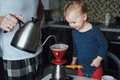 Father teaches his daughter to cook at home in the kitchen. Dad makes coffee at home - PhotoDune Item for Sale