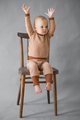 Portrait cute one year old baby girl, sitting on a wooden chair, gesturing with hands - PhotoDune Item for Sale