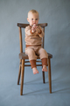 Portrait cute one year old baby girl, sitting on a wooden chair, gesturing with hands. - PhotoDune Item for Sale