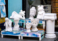 Different plaster figures in the window of a garden shop. Unusual planters for plants. - PhotoDune Item for Sale