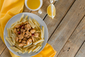 Penne pasta with  chicken in a creamy sauce on a light wooden background. - PhotoDune Item for Sale