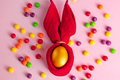 Golden Easter eggs and candies on a pink background. Happy spring holiday - PhotoDune Item for Sale
