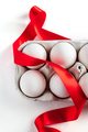 Easter eggs in a cardboard box with a red festive ribbon on a white background. - PhotoDune Item for Sale