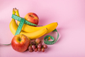 Measuring tape and juicy fruits on a pink background. The concept of diet and weight loss. - PhotoDune Item for Sale