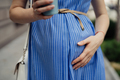 Pregnant woman touching her belly while walking - PhotoDune Item for Sale