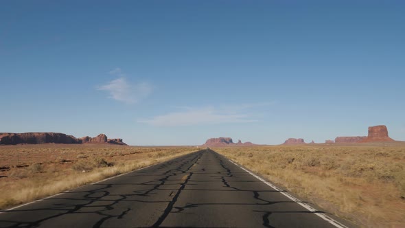 Driving On The Road Through The Hot Desert In Monument Valley On A Sunny Day