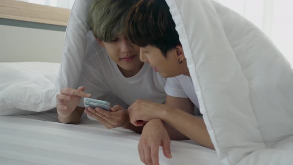 Asian gay couple using smartphone