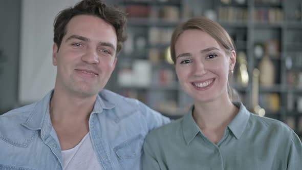 Portrait of Cheerful Couple Waving and Smiling at the Camera