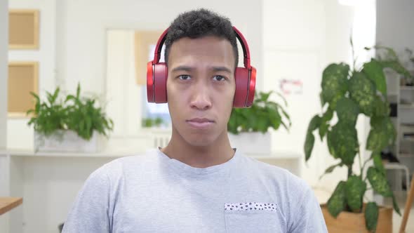 African Man Removing Red Headphones After Listening Music