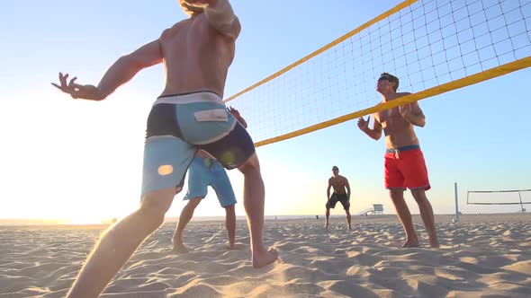Men playing beach volleyball.
