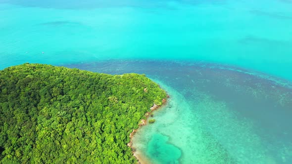 Daytime fly over tourism shot of a paradise sunny white sand beach and aqua blue ocean background in