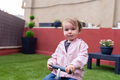 Little girl looking at camera while using a plastic bike - PhotoDune Item for Sale
