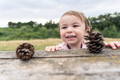 Little girl playing with pine cones from a tree - PhotoDune Item for Sale