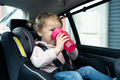Little girl drinking water inside a car - PhotoDune Item for Sale