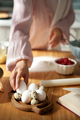 Close-up hand taking egg for kneading dough in kitchen. Woman bakes pie or cake at home - PhotoDune Item for Sale