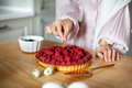 Close-up of woman's hands decorating raspberry tart, cooking delicious cake with fresh berries - PhotoDune Item for Sale