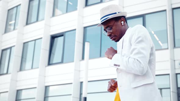 Professional black dancer in white suit and hat dances