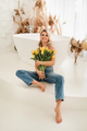 Cute smiling girl with a bouquet of yellow tulips in the interior - PhotoDune Item for Sale