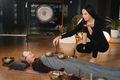 A young beautiful woman is doing a massage with singing bowls and a koshi bell to another girl - PhotoDune Item for Sale