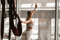 Portrait of a girl in white sportswear Standing near the window and holding a hanging hammock in her - PhotoDune Item for Sale