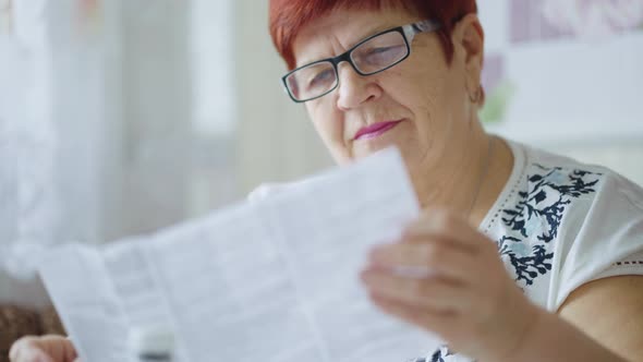 Elderly Woman Reading Instruction To Drugs