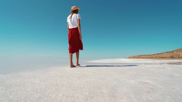 Rear and Low Point of View Cheerful Woman in Red Skirt Walking By Salt White Beach and Enjoying