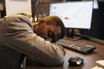 ng at work after finishing company strategy. Tired fatigued executive manager sleeping on desk in office workspace after overtime work