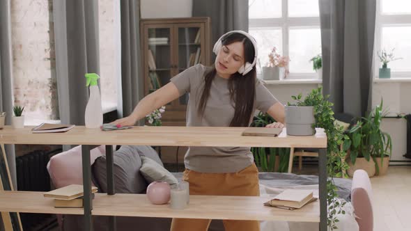 Happy Woman Enjoying Music and Cleaning Apartment