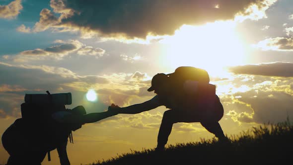 Silhouette of the Team on the Peak of Mountain. Sport and Active Life of People. Teamwork Assistance