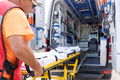 Lifeguard worker working while grabbing a stretcher on an ambulance - PhotoDune Item for Sale