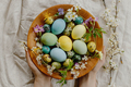 Happy Easter! Hands holding wooden bowl with stylish easter eggs and blooming spring flowers - PhotoDune Item for Sale