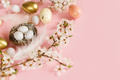 Stylish Easter eggs in nest, cherry blossoms and feathers on pink background with copy space - PhotoDune Item for Sale