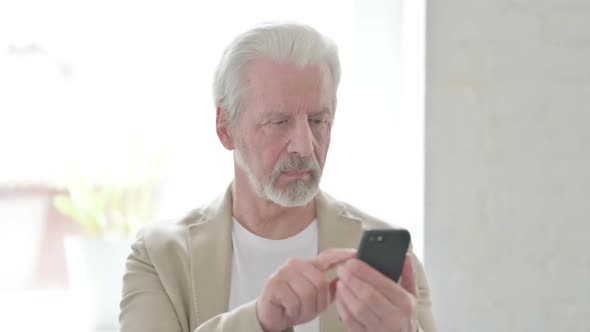 Old Man Browsing Internet on Smartphone