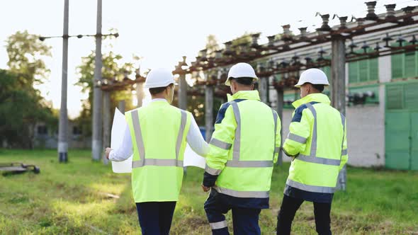 Back View Group of Diverse Specialists in the Middle of Construction Site they Analyzing the Plan