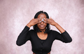Frontal view of afro woman with her eyes covered by her hands. - PhotoDune Item for Sale