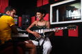In a recording studio, an Afro woman sits with a guitar. - PhotoDune Item for Sale