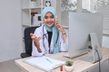 Happy muslim doctor giving telephone consultation, talking to patient on mobile phone - PhotoDune Item for Sale