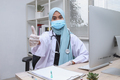 Young muslim woman with doctor gown and protective mask showing thumb up at clinic - PhotoDune Item for Sale