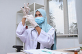 Female muslim doctor or nurse with protective work wear holding syringe at clinic - PhotoDune Item for Sale