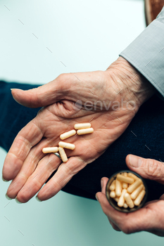 hand of elderly person with medicines on the palm