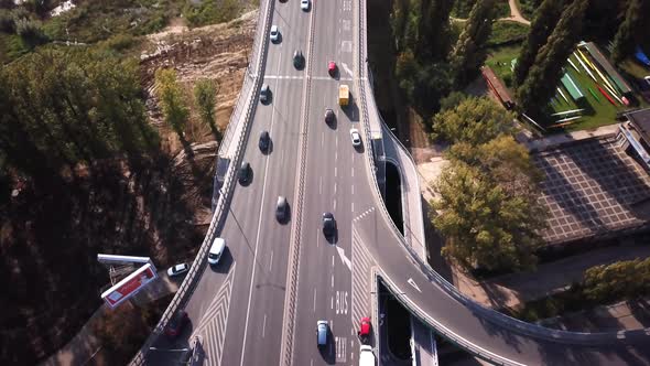 Aerial shot focuses on yellow truck crossing the bridge, traffic on the bridge. Cars driving. 4K. Cr