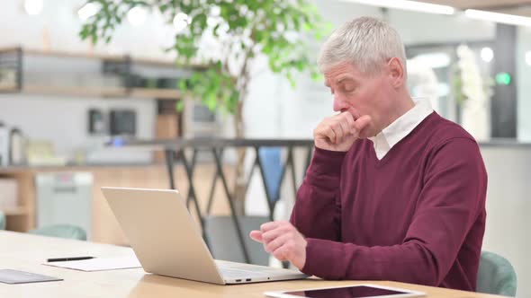 Sick Middle Aged Man with Laptop Coughing