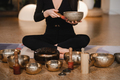 A woman in the lotus position using a singing bowl indoors . - PhotoDune Item for Sale
