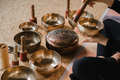 Close-up of a woman's hands sitting in a lotus position using a singing bowl indoors.  - PhotoDune Item for Sale