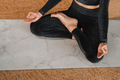 Close-up of the legs and arms of a woman in a black tracksuit sitting on  - PhotoDune Item for Sale