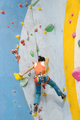 Young Woman rock climbing indoors. - PhotoDune Item for Sale