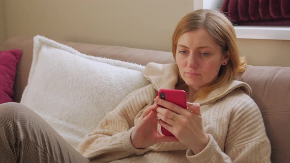 Woman On Sofa With Smartphone